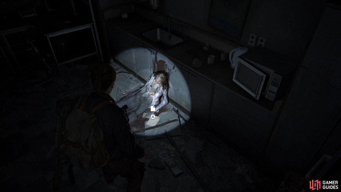 Crawl through the hole to the right of the stairs to find this Artefact by a body
