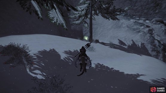 Approach the snowy ridge and look behind the tree.