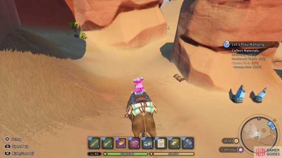 The chest is covered by some sand next to a rock pillar.