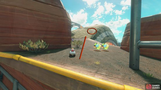 Take the slope to the top and look on top of the tire rock to your right to find the panel.