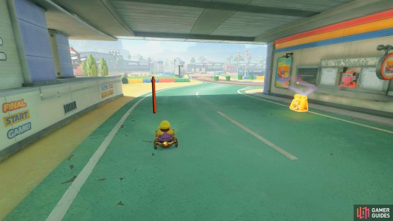 Follow the green road past the food spots and drive toward the barrier ahead.