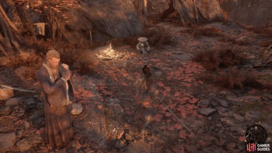 You can find Nian sitting down by the campfire next to the tents.
